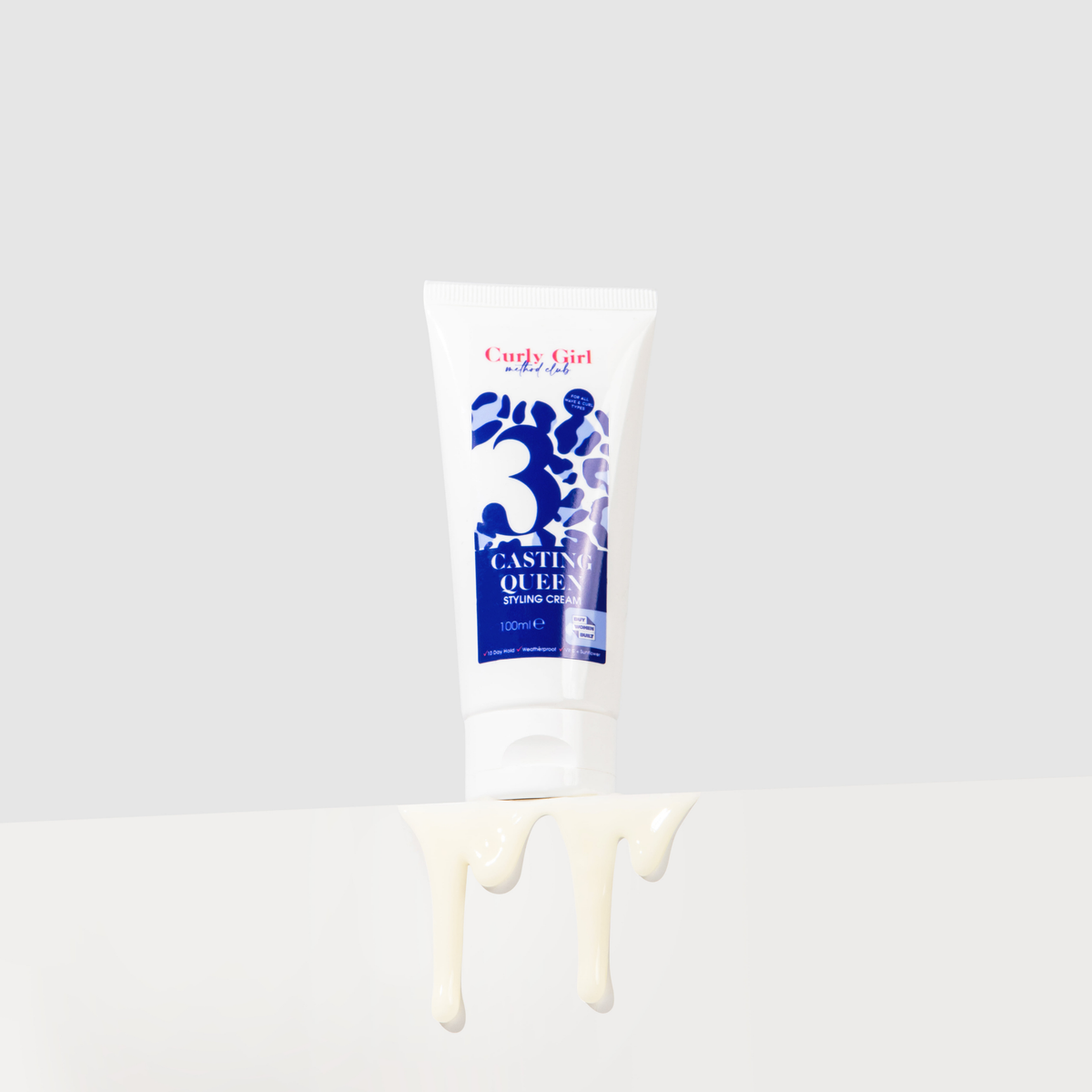 Tube of Curly Girl product with white cream dripping from it on a light gray background