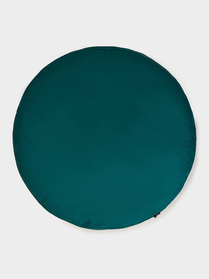Teal round cushion on a light gray background