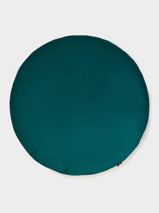 Teal round cushion on a light gray background