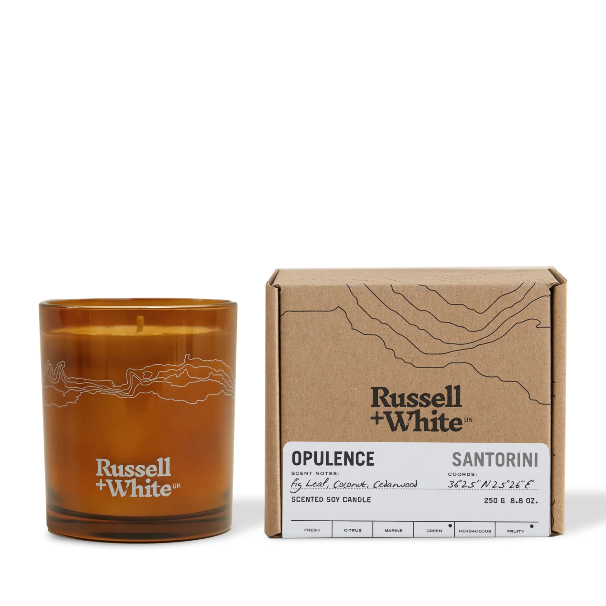 Brown candle with 'Russell + White' branding next to its packaging on a white background