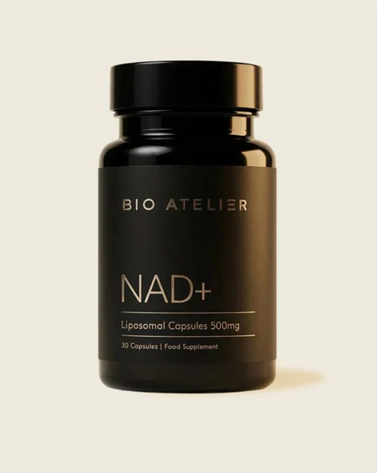 Black supplement bottle labeled 'BIO ATELIER NAD+' on a beige background