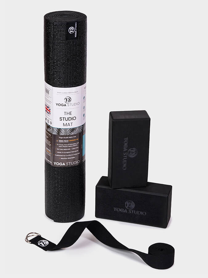 Yoga Studio black yoga mat, block, and strap on a white background