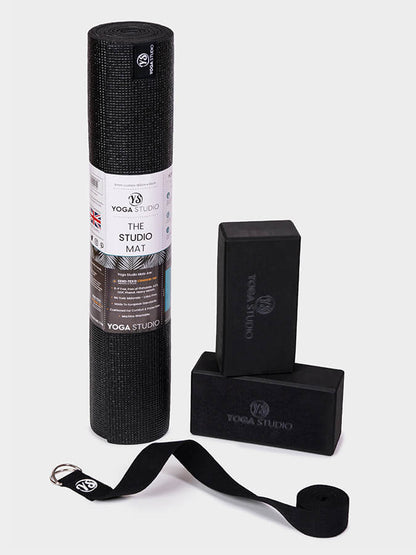 Yoga Studio black yoga mat, block, and strap on a white background