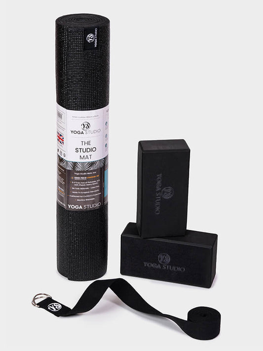 Yoga Studio black yoga mat, block, and strap on a white background