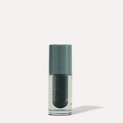 Skincare serum bottle with green cap and label on a light gray background