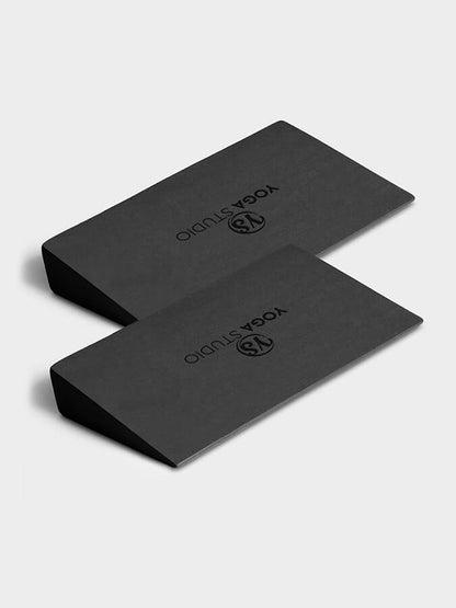 Two black yoga blocks with 'Yoga Studio' branding on a light gray background