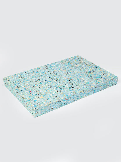 Rectangular turquoise foam pad with speckled pattern on a light gray background