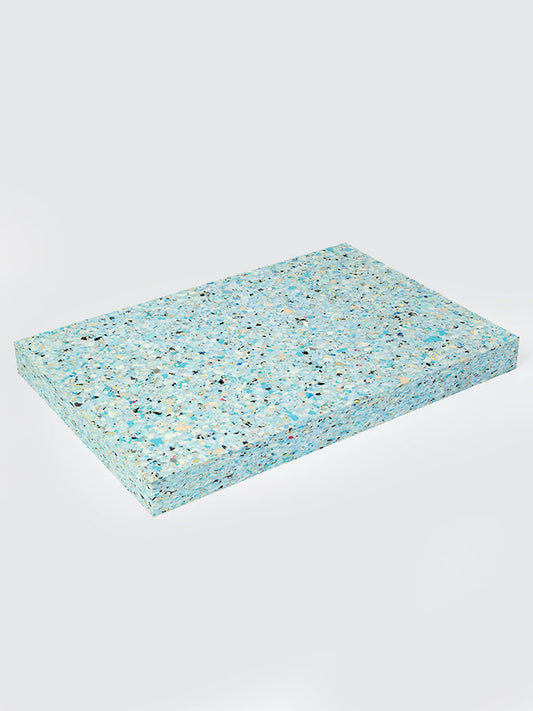 Rectangular turquoise foam pad with speckled pattern on a light gray background
