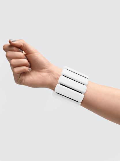 A white segmented wrist cuff bracelet worn on a person's wrist, shown against a plain light gray background.