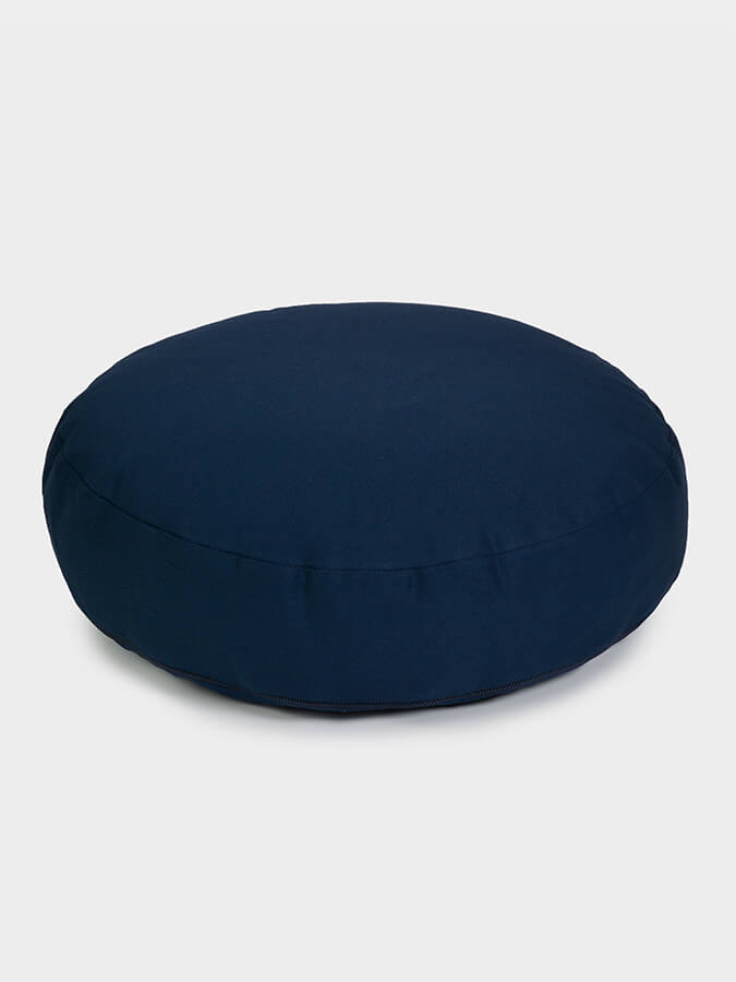 Navy blue zafu cushion on a light gray background