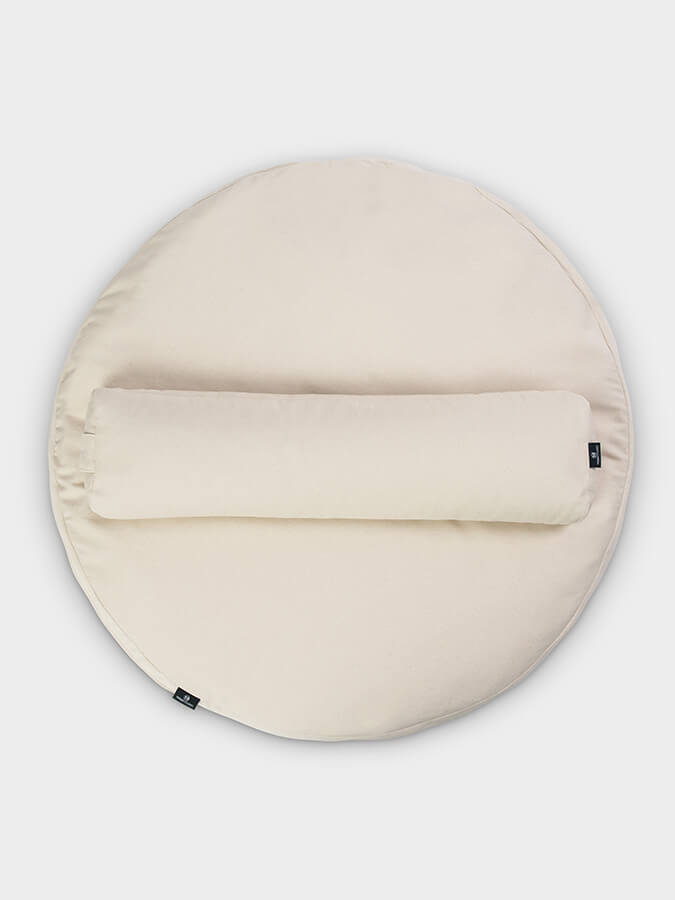 Round beige cushion with a zipper on a light gray background